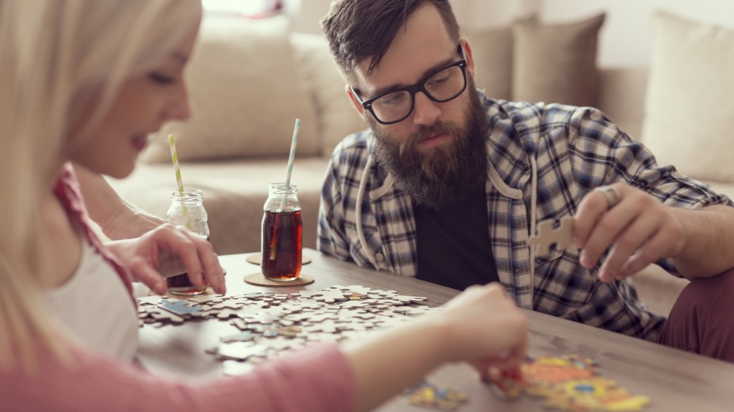 Woman working on a puzzle with her boyfriend - GET to stay home